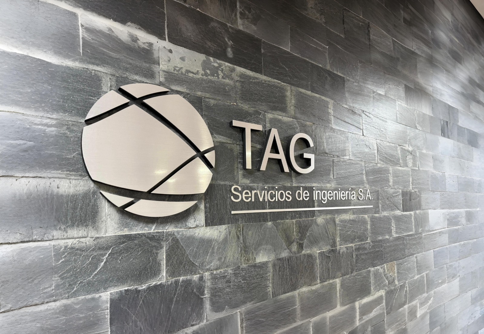 Wordmark de TAG sobre muro de oficina